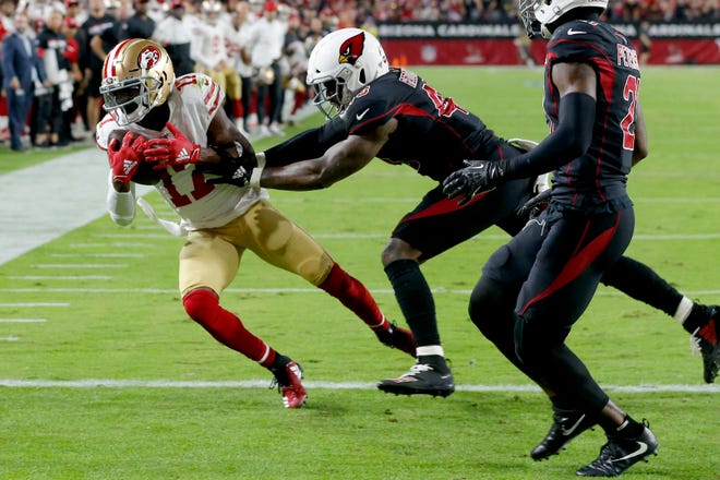 San Francisco 49ers wide receiver Emmanuel Sanders (17) scores a touchdown as Arizona Cardinals outside linebacker Haason Reddick defends during the first half of an NFL football game, Thursday, Oct. 31, 2019, in Glendale, Ariz. (AP Photo/Rick Scuteri)