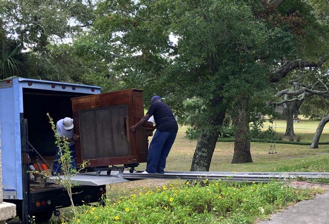 Greg Cooper, left, and Freddie Bryant ease a piano across a 6-foot drop. [Ben Goggins/For Savannah Morning News]