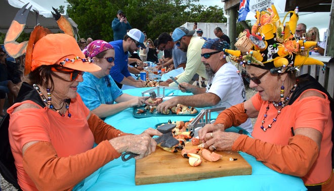 Sandra Bradshaw, left, and Sally Mishmash compete in the team division of the Keys Fisheries Stone Crab Eating Contest on Saturday in Marathon. Competitors were judged on their ability to cleanly consume 25 stone crab claws in the quickest time. The Florida Keys is Florida's top regional supplier of stone crab claws, considered a renewable marine resource because of the crab's ability to re-grow harvested claws. [LARRY BENVENUTI/FLORIDA KEYS NEWS BUREAU]
