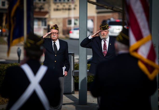 Chaplain Charlie Kampka, left, and Commander Steven Ackerman, of Newton VFW Post 5360, salute the American flag during a brief Veterans Day ceremony at the Newton Green Monday. [Photo by Daniel Freel/New Jersey Herald (NJH)]
