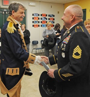 Patrick Crawford, of Lindsborg, wearing the Color Guard uniform for Sons of the American Revolution, meets with Jack Jackson. Army National Guard Active Guard Reserve, before the Veterans Day assembly at the Salina South Middle School on Monday. During the assembly five local Veteran's were honored.  [AARON ANDERS/SALINA JOURNAL]