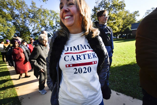 In this Sunday, Nov. 3, 2019, photo, Tammy Bailey wears a message on her shirt as she waits in line to attend former President Jimmy Carter's Sunday school class at Maranatha Baptist Church, in Plains, Ga. (AP Photo/John Amis)