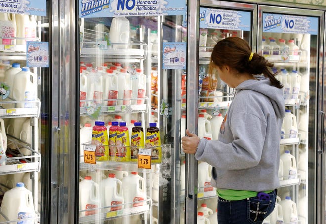 A customer reaches for a container of milk at a grocery store in Edmond, Okla. On Tuesday, Dean Foods, the nation's largest milk processor, filed for Chapter 11 bankruptcy protection and said it may sell the company off to the Dairy Farmers of America. [Sue Ogrocki/The Associated Press file]