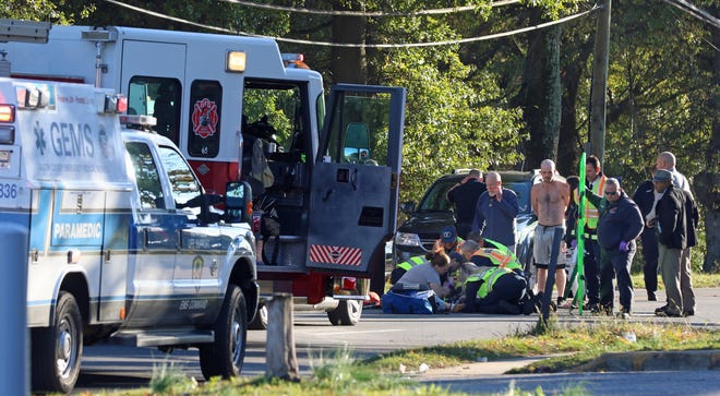 Emergency crews treat a girl who was struck by a car while crossing South York Street Tuesday afternoon. [MIKE HENSDILL/THE GASTON GAZETTE]