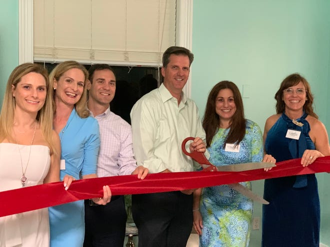 Jupiter Mayor Todd Wodraska, center, cuts the ribbon at Therapeutic Oasis of the Palm Beaches’ grand opening event for its Jupiter location last week. [PHOTO PROVIDED BY BLUEIVY COMMUNICATIONS]