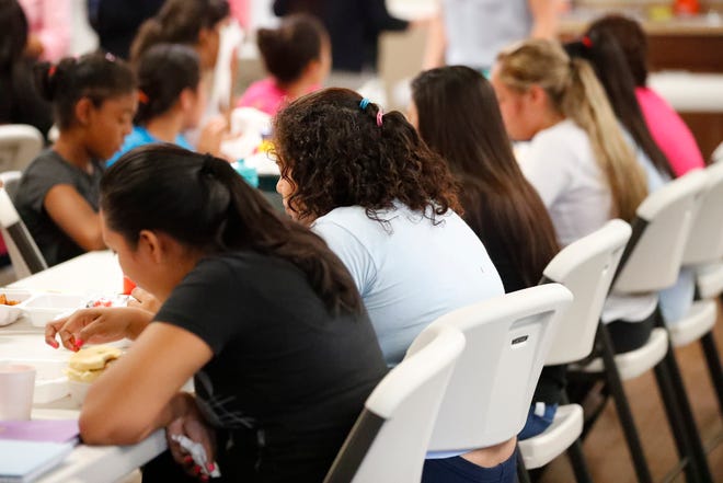 In this Sept. 24, 2019 photo, girls eat lunch at a shelter for migrant teenage girls, in Lake Worth, Fla. The nonprofit U.S. Committee for Refugees and Immigrants opened the federally funded Rinconcito del Sol shelter this summer, aiming to make it a model of excellence in a system of 170 detention centers, residential shelters and foster programs which held nearly 70,000 migrant kids in the past year. (AP Photo/Wilfredo Lee)