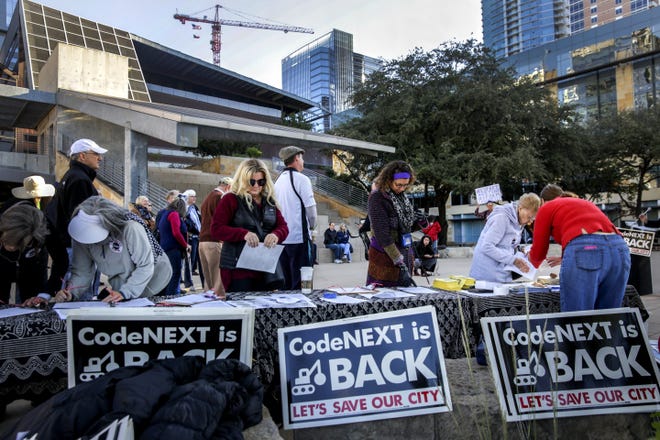 Several people sign a petition against the proposed city zoning code during a rally at Austin City Hall in late October. On Tuesday night, the city’s Planning Commission approved its recommendation on the land development code rewrite. [BRONTE WITTPENN/AMERICAN-STATESMAN]