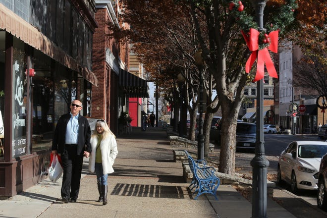 In this file photo, a couple walks down Jefferson Street Nov. 11 for the annual kick-off to the shopping season during Downtown Open House in Burlington. Downtown Burlington is home to 123 buildings, 192 employers and nearly 1,500 employees.

 [John Gaines/thehawkeye.com]