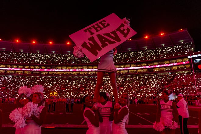 Alabama cheerleaders encourage a wave as the new LED lights bathe the stadium in a red glow during the second half against Tennessee on Saturday, Oct. 19, 2019. [Associated Press]