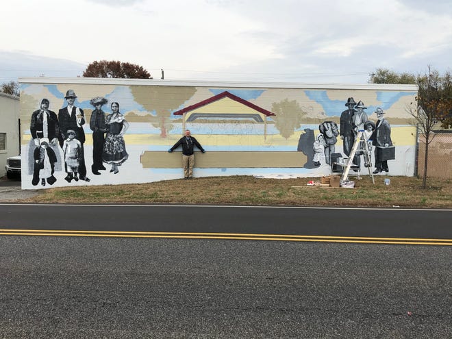 Artist Jean-Marc Dubus shows the size of the 500-square-foot mural he is painting on a side of the PKB Contractors building in Bristol Borough. [CONTRIBUTED]