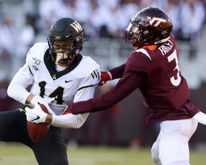 Wake Forest receiver Sage Surratt (14) catches a pass in front of Virginia Tech defender Caleb Farley (3) during the first quarter of a game Saturday in Blacksburg, Va. [Matt Gentry/The Roanoke Times via AP]