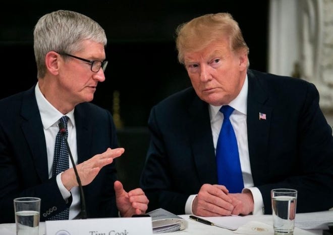 Apple Inc. CEO Tim Cook speaks with President Donald Trump during a March 6 meeting at the White House. [Al Drago/Bloomberg News Service]