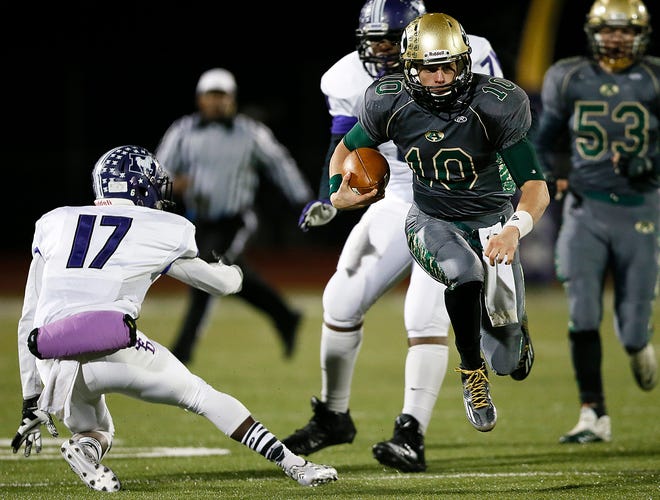 Joe Burrow, avoiding DeSales' Austin Andrews in a playoff game, led Athens to the Division III state championship game in 2014, where the Bulldogs fell 56-52 to Toledo Central Catholic. [Dispatch file photo]