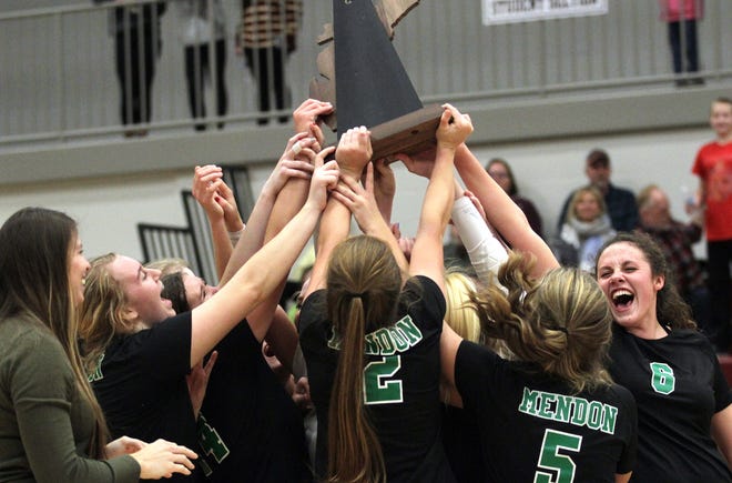 The Mendon volleyball team celebrates with the regional championship trophy after beating Battle Creek St. Philip on Thursday evening. [Brandon Watson/Journal]
