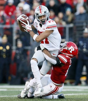 Ohio State Buckeyes wide receiver Chris Olave (17) makes a catch with Rutgers Scarlet Knights defensive back Christian Izien (12) hanging on his back during the first quarter of the NCAA football game at SHI Stadium in Piscataway, N.J. on Saturday, Nov. 16, 2019. [Adam Cairns/Dispatch]