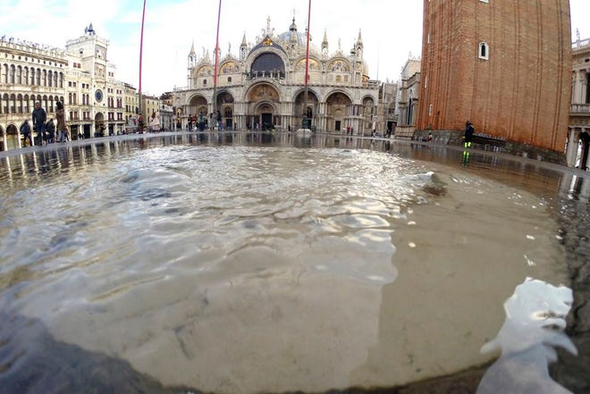 Water starts rising again in St. Mark square in Venice, Italy, Saturday, Nov. 16, 2019. High tidal waters returned to Venice on Saturday, four days after the city experienced its worst flooding in 50 years. (AP Photo/Luca Bruno)