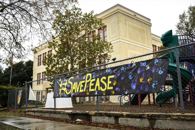 Pease Elementary School supporters painted and hung a sign outside of the 143-year-old school to encourage the school board to spare it from closure; the board plans to vote Monday night or Tuesday. Pease is one of four elementary schools district administrators have proposed to close in the 2020-21 school year. [BRONTE WITTPENN/AMERICAN-STATESMAN]
