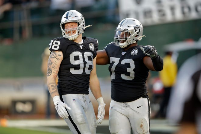 Oakland Raiders defensive end Maxx Crosby (98) is greeted by defensive tackle Maurice Hurst (73) after sacking Cincinnati Bengals quarterback Ryan Finley during the second half of an NFL football game in Oakland, Calif., Sunday, Nov. 17, 2019. (AP Photo/Ben Margot)