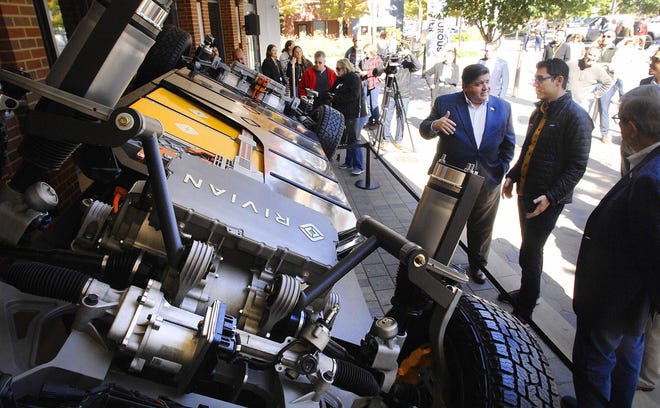 Illinois Governor J.B. Pritzker, left, talks with RJ Scaringe, CEO of Rivian Automotive, about the company's innovative electric vehicle chassis called a "skateboard" during Rivian's public rollout of its new prototype vehicles Oct. 13 in Normal, Illinois. The company is manufacturing a pickup and the sports utility vehicle as the world's first electric "adventure vehicles" in Normal. [David Proeber/The Pantagraph]