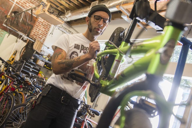 Henry Rocha, the program manager for New Standard Cycles, inspects a bike donated to Bike Walk Savannah's Holiday Bike Drive. [Will Peebles/Savannahnow.com]