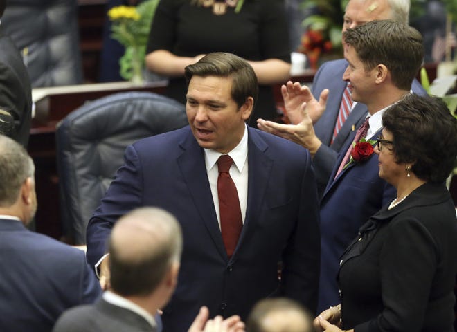 Gov. Ron Desantis, center, is greeted by lawmakers before he gives his state of the state address on first day of legislative session Tuesday, March 5, 2019, in Tallahassee, Fla. [AP Photo/Steve Cannon]