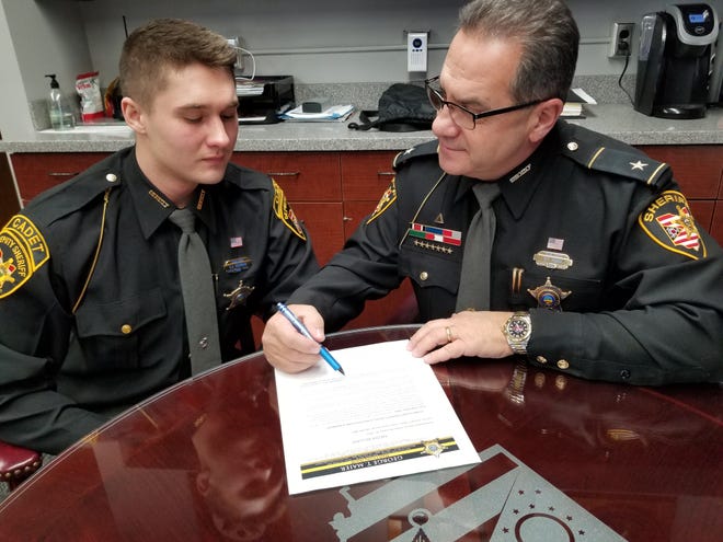 The first cadet in the Stark County Sheriff’s Office program, Zachary Yadrnak (left) gets direction from his boss, Sheriff George T. Maier.  (Lori Steineck / The Canton Repository)