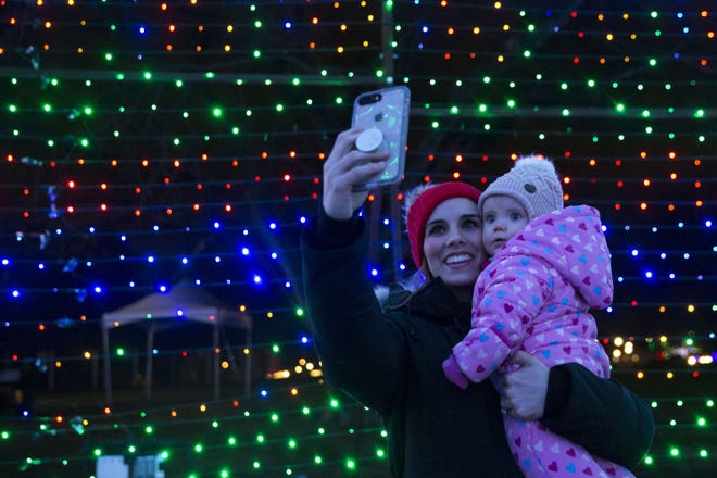Katie Cigarroa takes a selfie with her daughter, Emmy, inside the rainbow tunnel at the Trail of Lights in Zilker Park. [AMERICAN-STATESMAN]