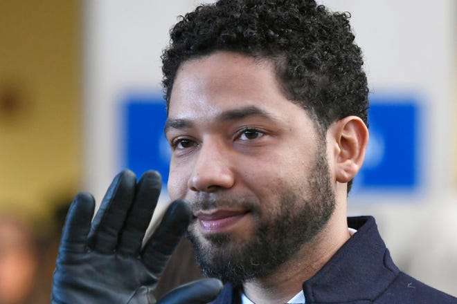FILE - In this March 26, 2019 file photo, former "Empire" actor Jussie Smollett smiles and waves to supporters before leaving Cook County Court after his charges were dropped in Chicago. Smollett says his $10,000 payment after the close of a criminal case should prevent Chicago from seeking reimbursement for a police investigation of his claim that he was a victim of a racist and homophobic attack. Smollett's attorneys filed a response to Chicago's lawsuit Tuesday, Nov. 19, 2019. They also filed a counterclaim against the city, saying Smollett was the victim of a malicious prosecution. Smollett told police he was beaten by two men. Police said it was staged.(AP Photo/Paul Beaty, File)