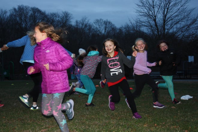 Mikaela Richter, center, is flanked to the left by Lauren Gault and to the right by Embry Kenney and Abby Mikolinski in a game of "blob tag" as part of the Girls on the Run program at Salem School. [Contributed]