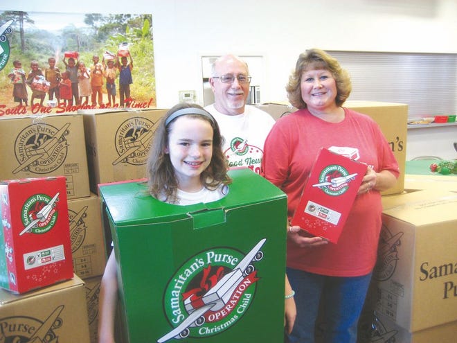 Madison Grove, daughter of Pastor David and Amy Grove of Ebenezer Church, and the church's Operation Christmas Child coordinators Alvin and Michelle Strite were among those on hand Tuesday during the shoebox collection. SHAWN HARDY/ECHO PILOT