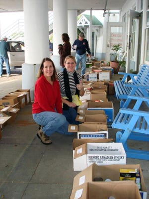 Kay Biggers and Katie Wright work to get the boxes ready for the Fishermen's Foundation distribution day for those Destin fishermen in need during the holidays. The distribution area is set up at the Destin Fishermen's Co-Op. [CONTRIBUTED PHOTO]