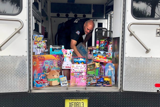 Fort Walton Beach Police Lt. Matt Holt loads toys into the S.W.A.T truck Friday for the toy drive. [ERIN FRANCZAK/ DAILY NEWS]