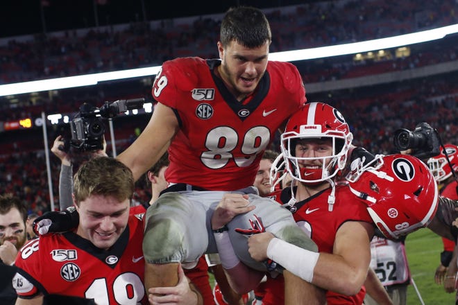 Georgia senior tight end Charlie Woerner (89) is carried off the field by Bulldog teammates after his final game on Dooley Field at Sanford Stadium. The Bulldogs sent him out a winner, 19-13. [Photo/Joshua L. Jones, Athens Banner-Herald]