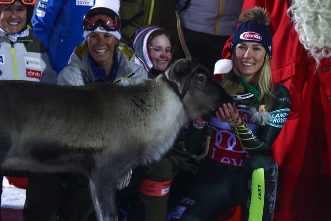 United States' Mikaela Shiffrin feeds a reindeer during the podium ceremony after winning an alpine ski, women's slalom in Levi, Finland, Saturday, Nov. 23, 2019. (AP Photo/Alessandro Trovati)