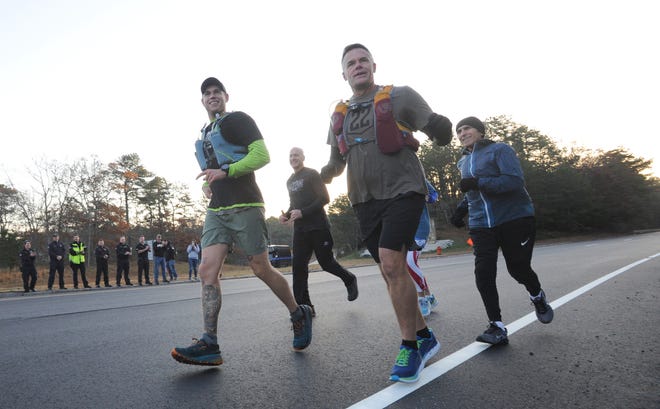 Josh Milich, left, and Brian Tjersland acknowledge a group of supporters gathered around the Otis Rotary on Nov. 11 as they start their run to Arlington National Cemetery. The duo finished the 500-mile run to help prevent veteran suicide on Friday afternoon. [Merrily Cassidy/Cape Cod Times file]