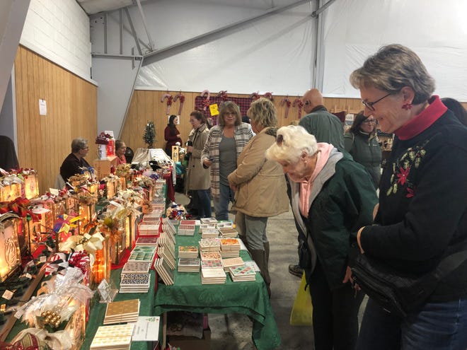 Linda Benzing, shows her glass block decorations and coasters, to a customer at her booth. [Photo by Jennifer Jean Miller/New Jersey Herald (NJH)]