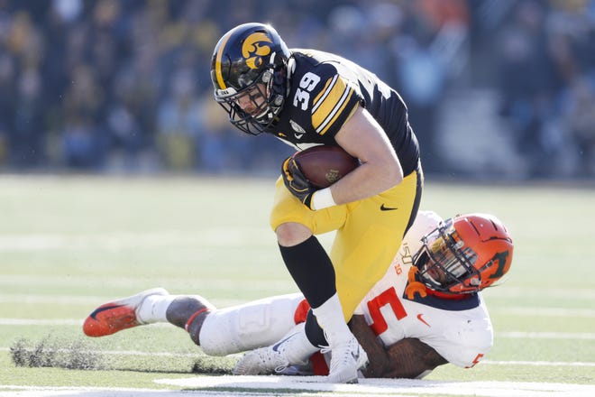 Iowa tight end Nate Wieting (39) breaks a tackle by Illinois linebacker Milo Eifler (5) after catching a pass on Saturday. [Charlie Neibergall/The Associated Press]