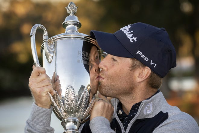Tyler Duncan kisses the trophy after a winning a second hole playoff against Webb Simpson during the final round of the RSM Classic golf tournament in St. Simons Island, Ga., Sunday, Nov., 24, 2019. (AP Photo/Stephen B. Morton)