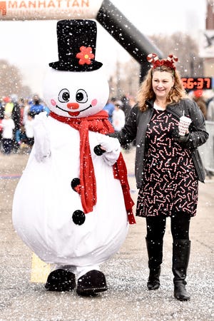 Jennie Graham and Frosty the Snowman greet the participants and spectators before the Big Brothers Big Sisters of Salina Frosty Fun Run early Saturday morning in downtown Salina at The City Teen Center. [KIM RAYAS/SALINA JOURNAL]