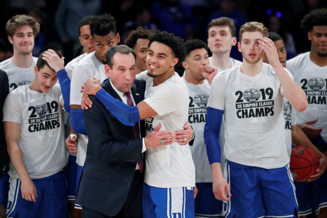 Duke guard Tre Jones (3) embraces coach Mike Krzyzewski after Duke defeated Georgetown in in the 2K Empire Classic last Friday. Duke remained at No. 1 in the latest national rankings. [ASSOCIATED PRESS]