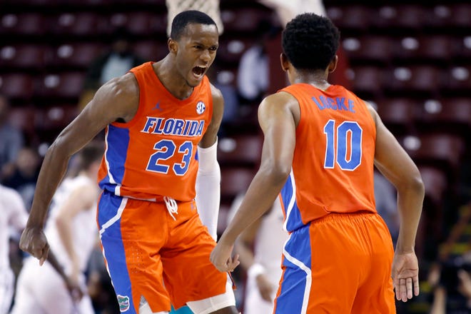 Florida's Scottie Lewis (23) shows the excitement with Noah Locke after forcing Xavier to call a timeout in the first half of the finals of the Charleston Classic on Sunday in Charleston, SC. [AP Photo/Mic Smith]