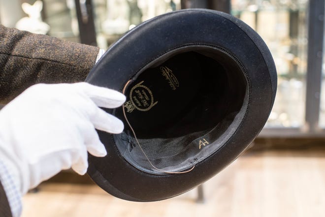 In this Wednesday, Nov. 20, 2019, photo, a person shows a personal top hat of Adolf Hitler with the initials 'AH' prior to an auction in Grasbrunn near Munich, Germany. A Geneva businessman says he has purchased Adolf Hitler's top hat and other Nazi memorabilia to keep them out of the hands of neo-Nazis and will donate them to a Jewish group. (Matthias Balk/dpa via AP)