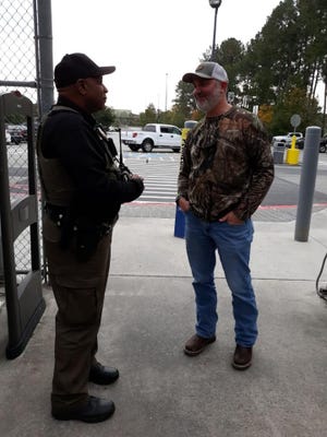 Jasper County Sheriff's Office patrol Sgt. Joe Bailey, left, speaks with a customer at a local store about the importance of making sure doors are locked and valuables are hidden from plain sight when parking vehicles to go shopping this holiday season. [Photo courtesy of Jasper County Sheriff's Office]