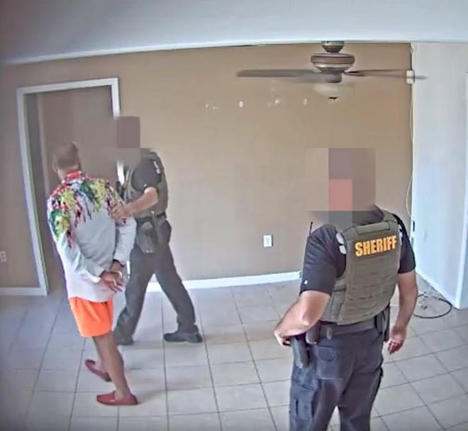 An image from video provided by the Sarasota County Sheriff’s office shows the arrest of a man accused of being an unlicensed contractor.