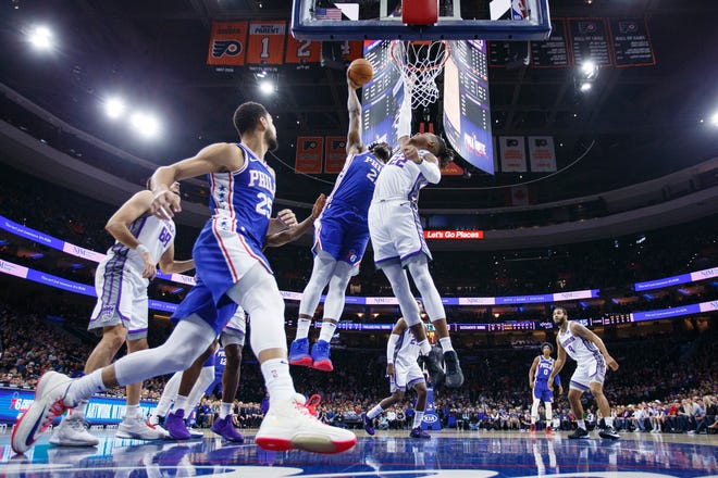 Sixers center Joel Embiid dunks over the Kings' Richaun Holmes during Wednesday night’s game. [CHRIS SZAGOLA / ASSOCIATED PRESS]