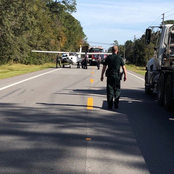 Flagler County sheriff’s deputies helped push a plane off County Road 205 after a pilot made an emergency landing there Wednesday when the aircraft ran out of fuel. [Photo provided by Flagler County Sheriff’s Office]