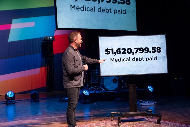 Jason Burns, founding and lead pastor of Access Church in Lakeland, reveals to his congregation Nov. 17 that their donations have paid off more than $1.62 million of past-due medical debt for city residents. [PROVIDED PHOTO]