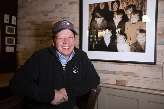 Paul Wahlberg sits next to an old family photo hanging in one of his restaurants, Alma Nove, in Hingham. It’s been over a decade since the entire Wahlberg family - all nine kids and their families included - got together on Thanksgiving under one roof. Lauren Owens Lambert/For The Patriot Ledger
