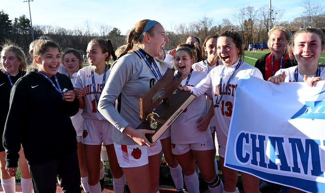 Holliston goalie Mary Katherine Ward, center, and teammates celebrate with the Division 2 state championship trophy after the 3-2 win over Winchester at Worcester State University Saturday. [Daily News and Wicked Local Staff Photo/Ken McGagh]