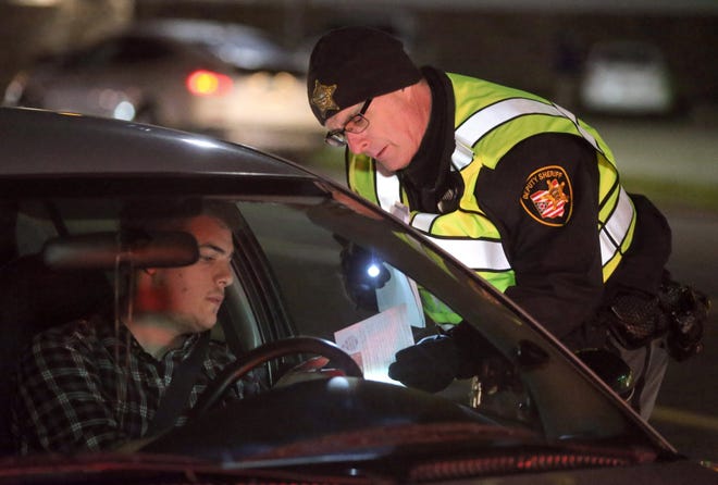 Stark County Sheriff Deputy Edward Eggan checks drivers during a OVI Task Force checkpoint on Everhard Road NW in Jackson Township last year in this file photo. (CantonRep.com / Scott Heckel)